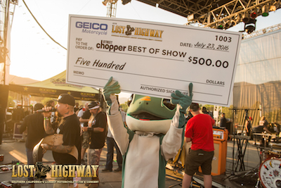 Geico Gecko presents the winner's check for the Lost Highway motorcycle show