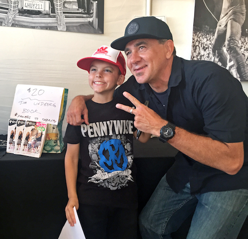 Pennywise's Jim Lindberg posing with a young fan at Lisa Johnson's Goldmine Garage at Surf City Blitz